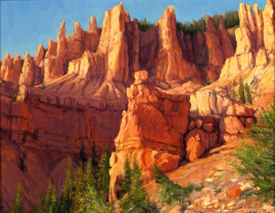 Up In The Breaks Vibrant red rock formations rise against a green forest backdrop.