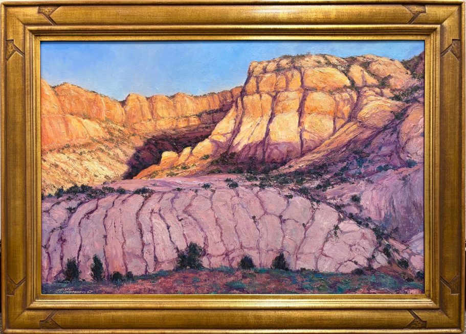 First Light Colorful rock formations with layered textures under a clear blue sky. Framed in gold.