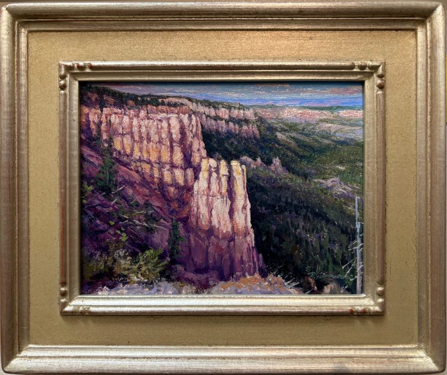 Bryce In Spires View of rugged rock formations and green valleys under a blue sky. Framed artwork.