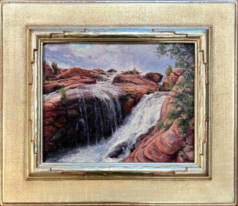 Overflowing - Gunlock Falls Waterfalls cascading over rocky terrain, framed by greenery and a cloudy sky.